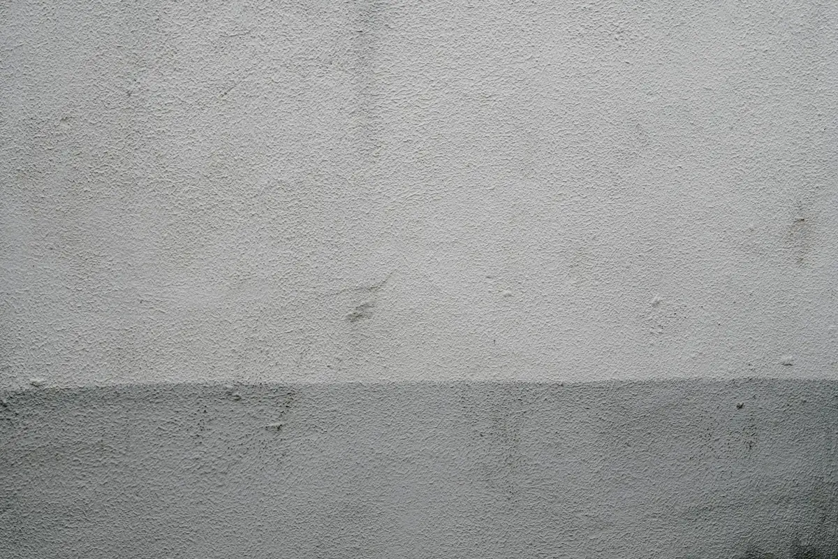 Mur enduit clair au-dessus d'un soubassement gris