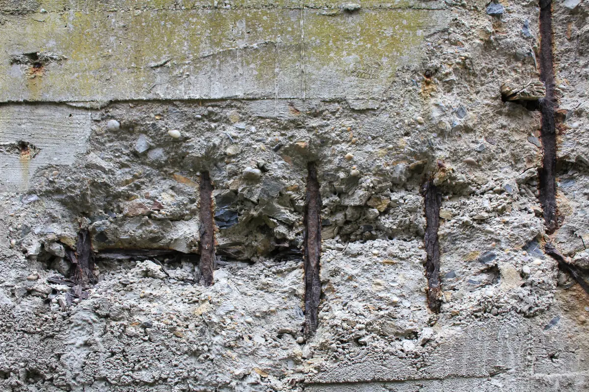 Béton armé éclaté sur un bunker de Keroman : les fers rouillés apparaissent sous le parement